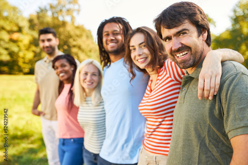 Diverse glückliche Gruppe Freunde umarmen sich in Natur