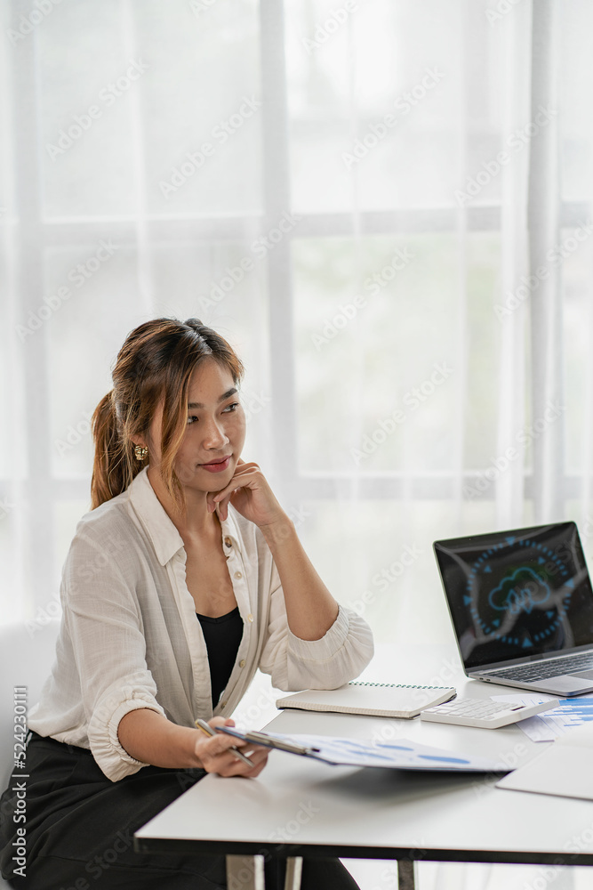 Asian business woman Use a laptop computer and work with the calculator documents on the desk. plan to analyze financial reports Invest in an office business plan Asian business woman Use a laptop computer and work with the calculator documents on the desk. plan to analyze financial reports Invest in an office business plan