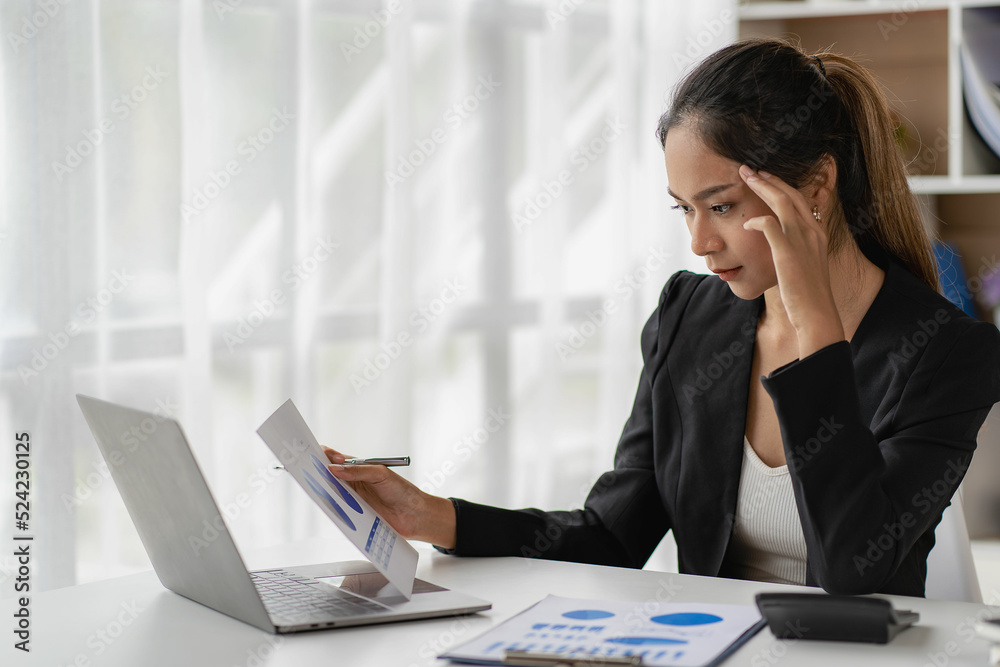 Asian business woman Use a laptop computer and work with the calculator documents on the desk. plan to analyze financial reports Invest in an office business plan Asian business woman Use a laptop computer and work with the calculator documents on the desk. plan to analyze financial reports Invest in an office business plan