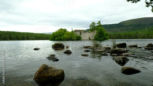 Two ducks are swimming in a tranquil lake habitat with an old castle in the background. a 4K video clip, Loch an Eilein, Rothiemurchus, Scotland. photo