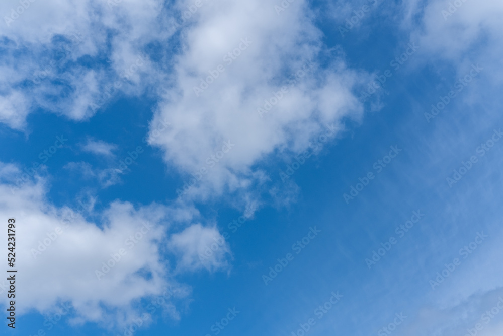 Blue sky background with white fluffy cumulus clouds. Panorama of white fluffy clouds in the blue sky. Beautiful vast blue sky with amazing scattered cumulus clouds. Blue sky background with white fluffy cumulus clouds. Panorama of white fluffy clouds in the blue sky. Beautiful vast blue sky with amazing scattered cumulus clouds.