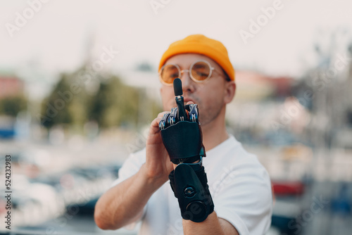 Young disabled man with artificial prosthetic hand in casual clothes showing fuck gesture