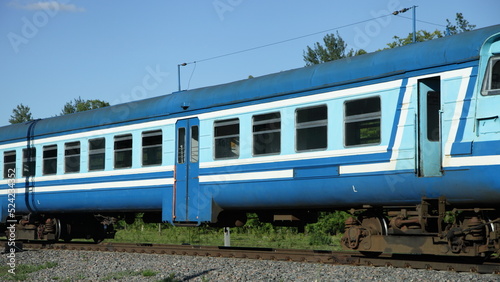 Old Russian suburban passenger blue train on one way railroad at summer day