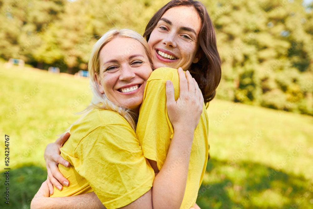 Zwei Frauen als beste Freundinnen umarmen sich glücklich - obrazy, fototapety, plakaty 