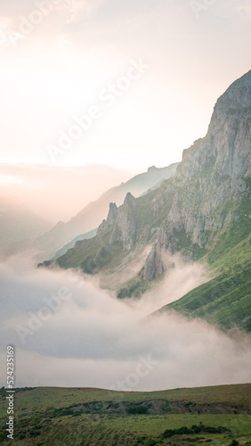 Sunset in the mountains with the clouds going up the hills 