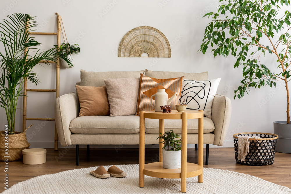 Scandinavian and cozy interior of living room with design beige sofa,  pillows, side tables, plants, bamboo ladder, carpet, decoration and  personal accessories. Stylish home decor. Template. Stock-foto | Adobe Stock