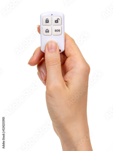 A woman's hand holds a wireless control key fob for a smart home, alarm, lock. Isolated on white background