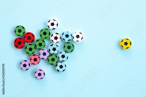 Wooden figures in the form of soccer balls on a blue background. Football time.