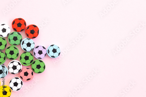 Wooden figures in the form of soccer balls on a pink background. Football time.