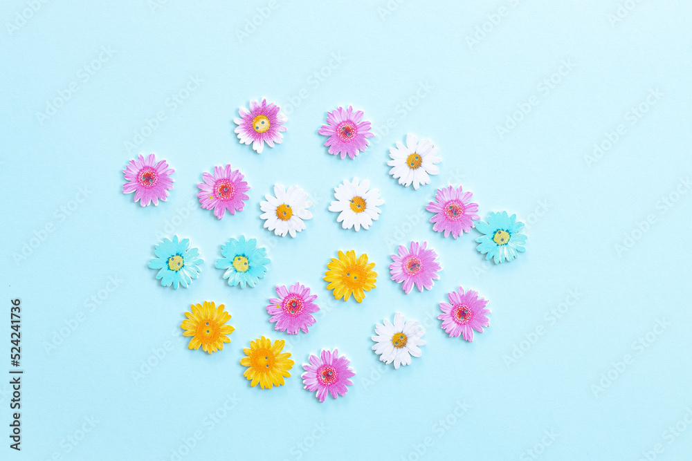Fototapeta premium Pattern of wooden colored flowers on blue background
