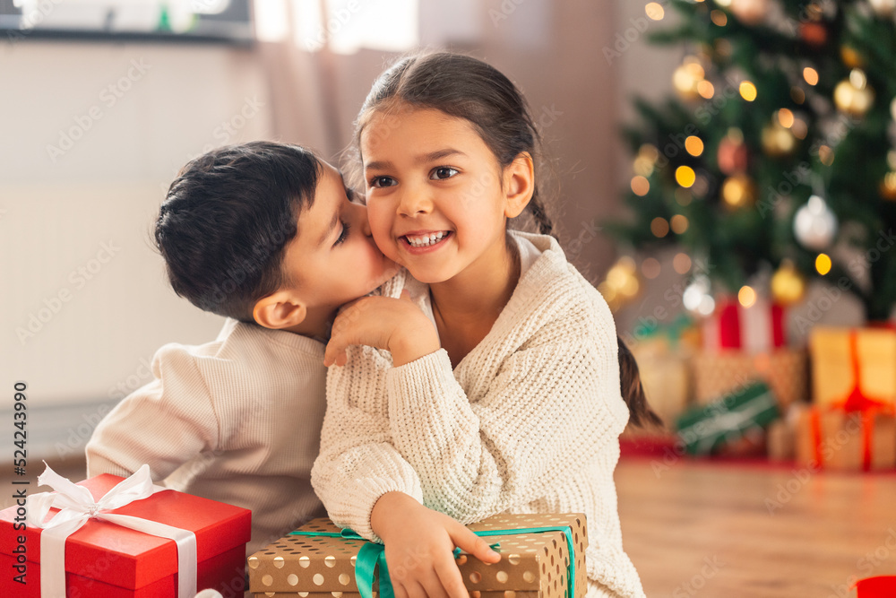 Φωτογραφία christmas, winter holidays and childhood concept - little boy kissing his happy