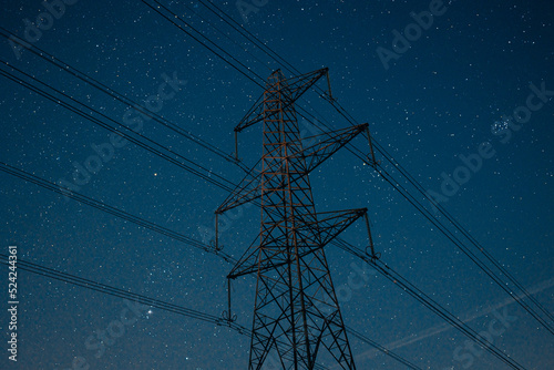 Newburn UK: March 2022: Looking up at electricity pylons on a clear starry night. Blue hour moody colours