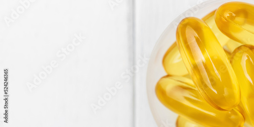 Omega-3 yellow capsules in a plastic scoop, nutritional supplements, close-up, top view