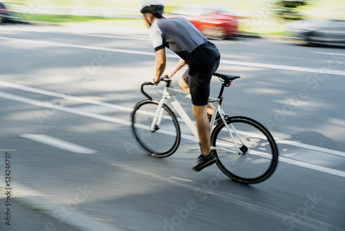 In motion blurred, a male athlete in gear rides a bike for highway training © muse studio