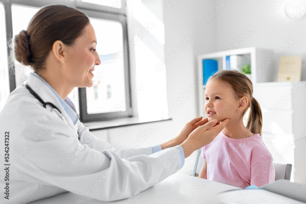 medicine, healthcare and pediatry concept - female doctor or pediatrician checking little girl patient's tonsils on medical exam at clinic medicine, healthcare and pediatry concept - female doctor or pediatrician checking little girl patient's tonsils on medical exam at clinic
