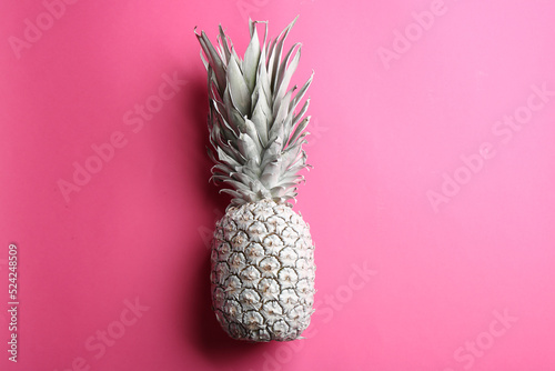 Painted white pineapple on pink background, top view. Creative concept