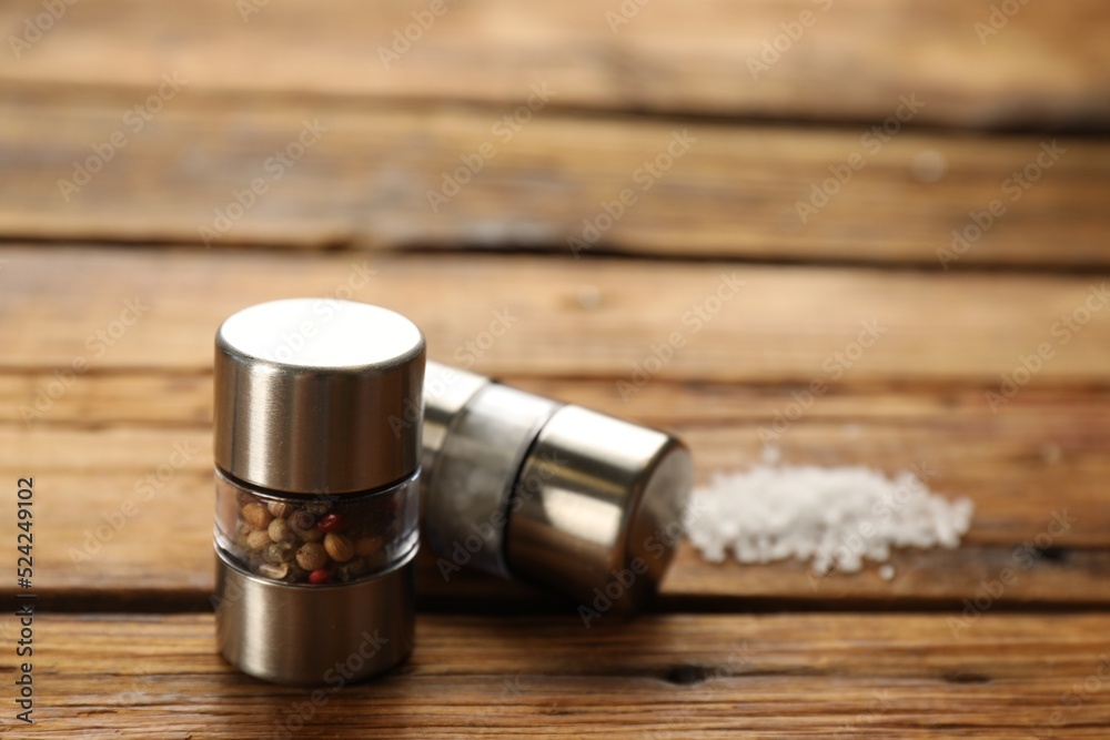 Salt and pepper shakers on wooden table, closeup
