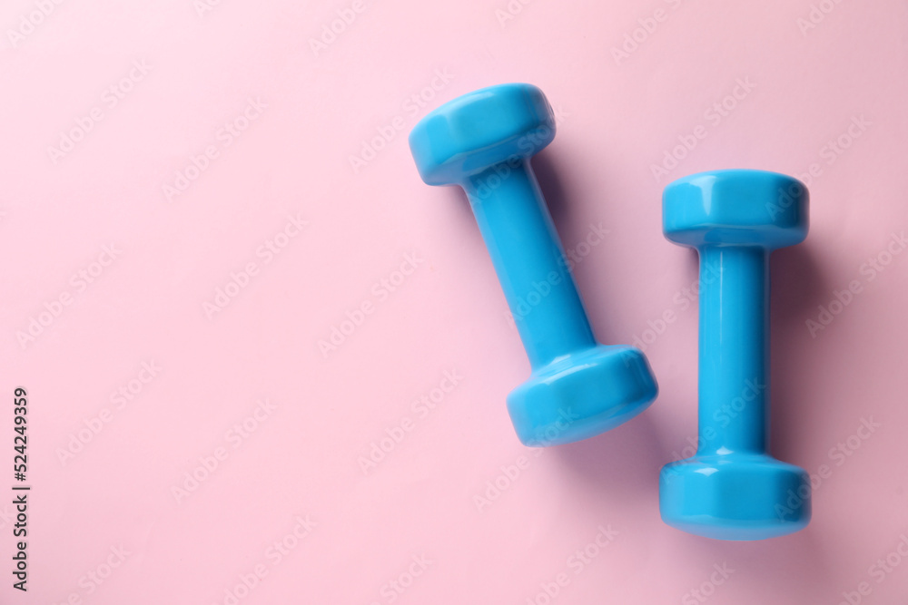 Turquoise dumbbells on pink background, flat lay. Space for text Turquoise dumbbells on pink background, flat lay. Space for text