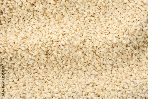 Pile of white sesame seeds as background, top view