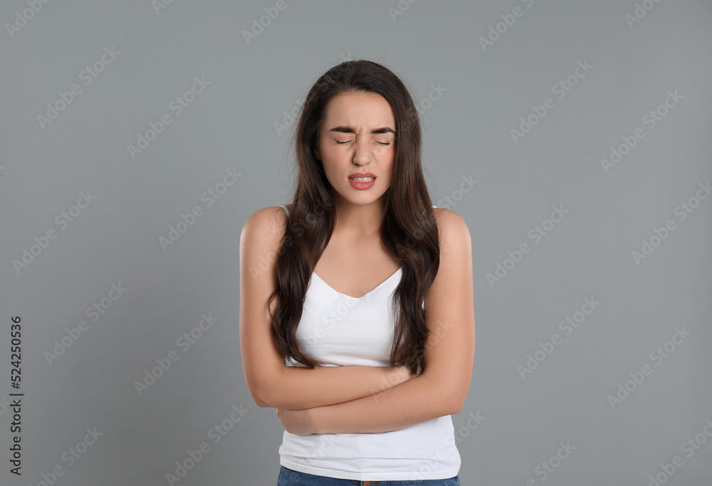 Young woman suffering from stomach ache on grey background. Food poisoning Young woman suffering from stomach ache on grey background. Food poisoning