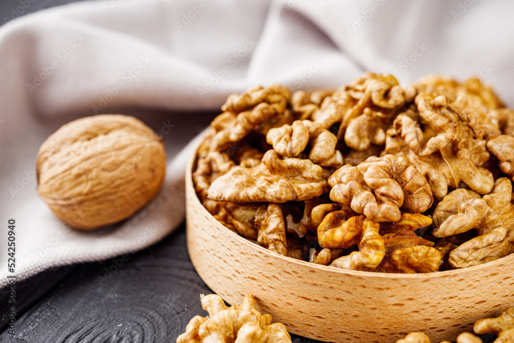 dried walnuts on a black rustic wooden background dried walnuts on a black rustic wooden background