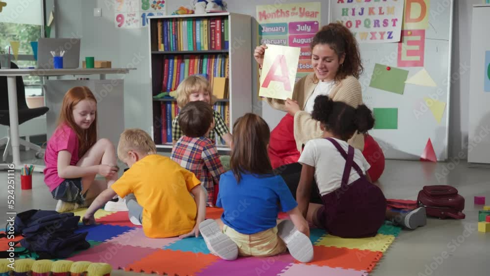 Female teacher hold flashcard with letter a teaching preschool kids