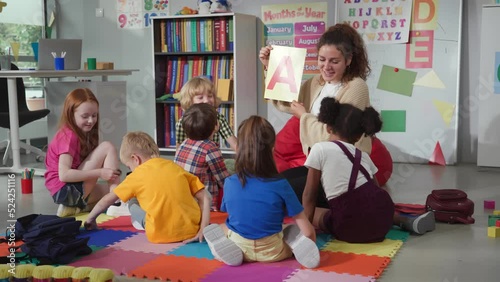 Female teacher hold flashcard with letter a teaching preschool kids alphabet