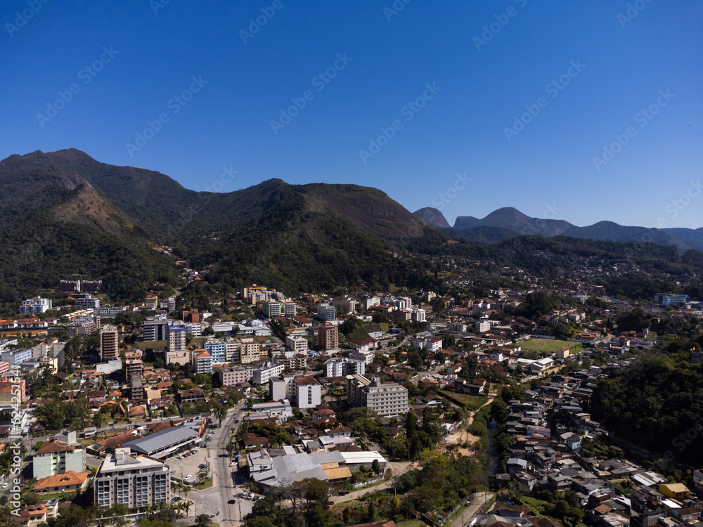 Aerial view of the city of Teresópolis. Mountains and hills with blue sky and many houses in the mountain region of Rio de Janeiro, Brazil. Drone photo. Araras, Teresópolis. Sunny day. Sunrise