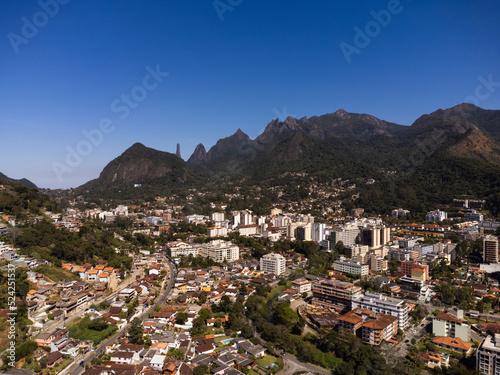 Aerial view of the city of Teresópolis. Mountains and hills with blue sky and many houses in the mountain region of Rio de Janeiro, Brazil. Drone photo. Araras, Teresópolis. Sunny day. Sunrise © Diego