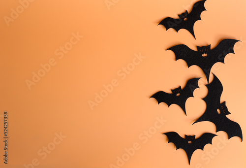 Five silhouettes of bats on a orange background. Creative halloween concept backdrop. halloween bats craft.