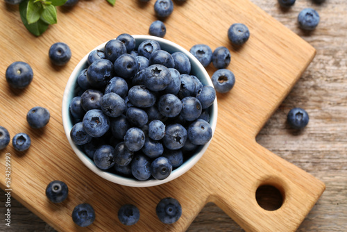 Tasty fresh blueberries on wooden table, flat lay