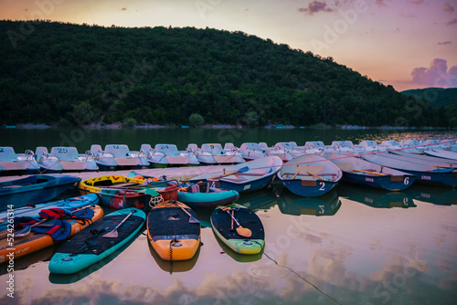 Recreation on the water: a beautiful lake landscape with sap boards, boats, catamarans standing near the shore photo