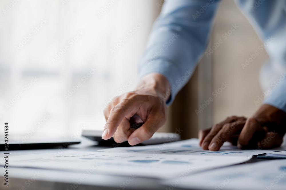 Business men are looking at the company's financial documents to analyze problems and find solutions before bringing the information to a meeting with a partner. Financial concept. Business men are looking at the company's financial documents to analyze problems and find solutions before bringing the information to a meeting with a partner. Financial concept.