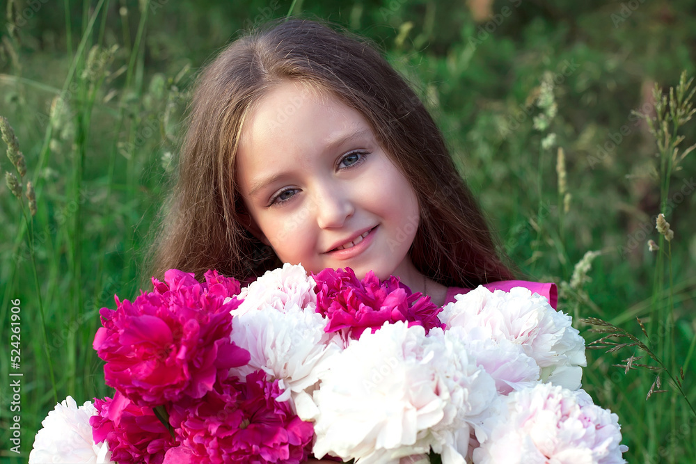 A little girl in a white dress with a bouquet of pink peonies on a blurry green background. Photo shoots in nature A little girl in a white dress with a bouquet of pink peonies on a blurry green background. Photo shoots in nature