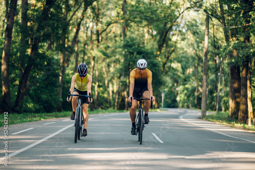 Couple riding road bicycles outside and wearing helmets and sunglasses © Zamrznuti tonovi