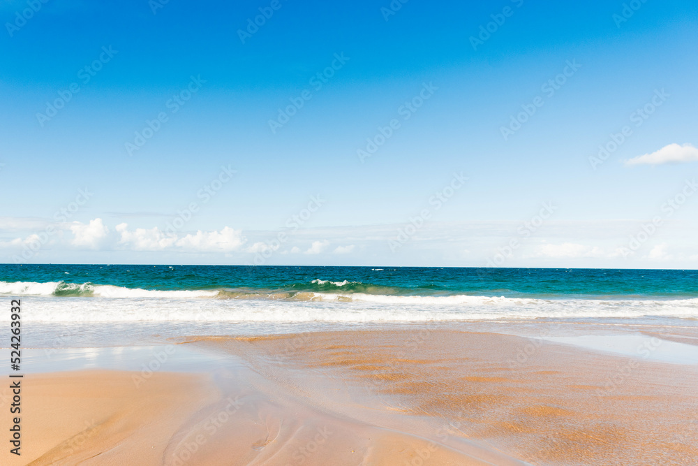 Ocean waves and sandy beach on a sunny day. Nature tropical background. Kellys Beach, QLD, Australia