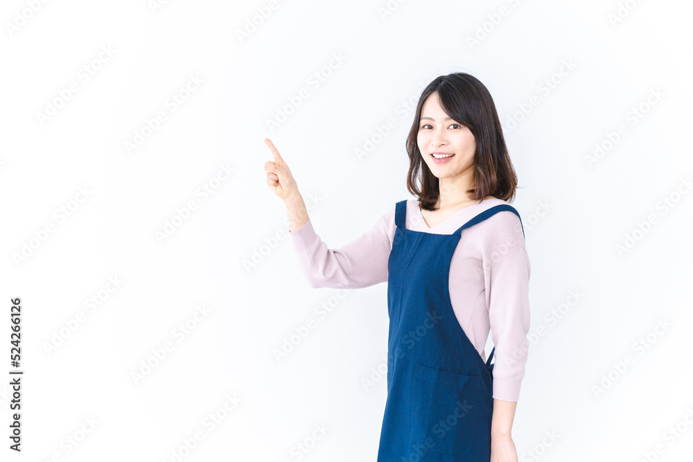 エプロンを着ておすすめを示す若い女性