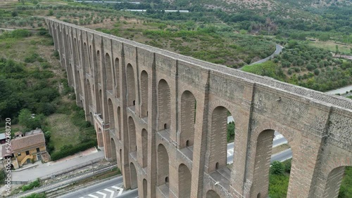 Aerial shot of the Aqueduct of Vanvitelli in Italy, with green lush trees in the background photo