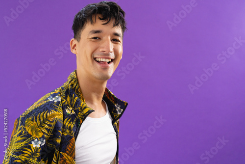 Portrait of happy biracial man looking at camera and smiling on purple background