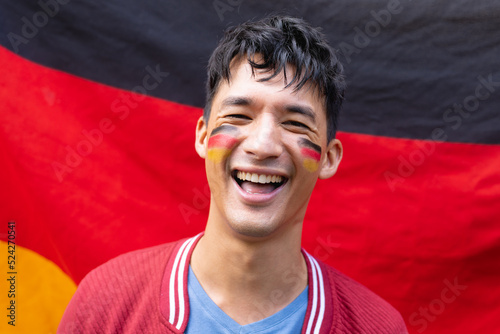 Portrait of happy biracial man smiling over flag of germany