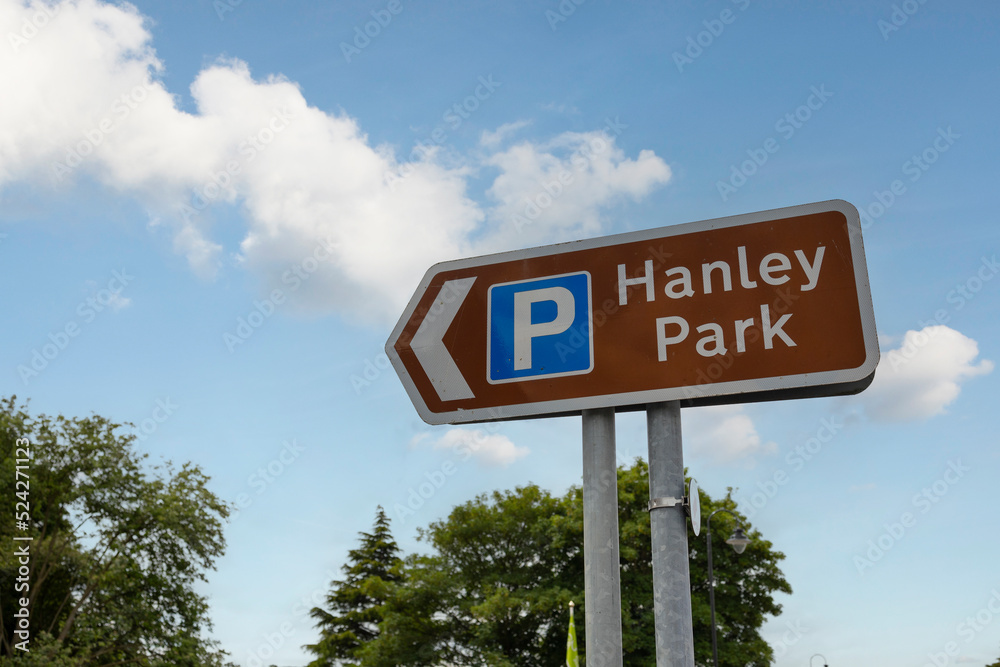 brown hanley park sign with blue parking sign blue sky