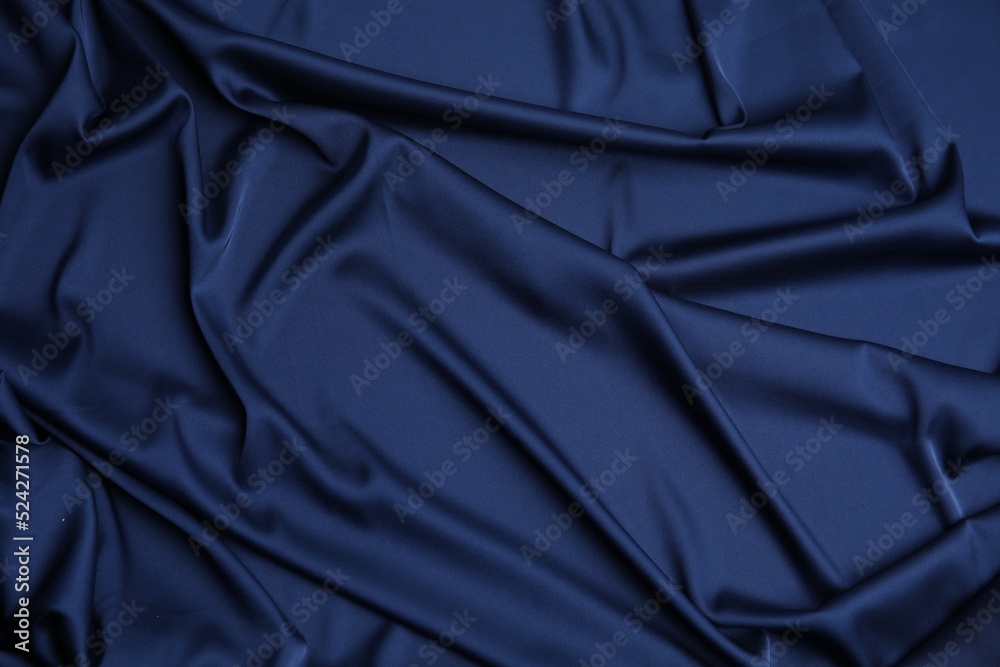 Crumpled dark blue silk fabric as background, top view