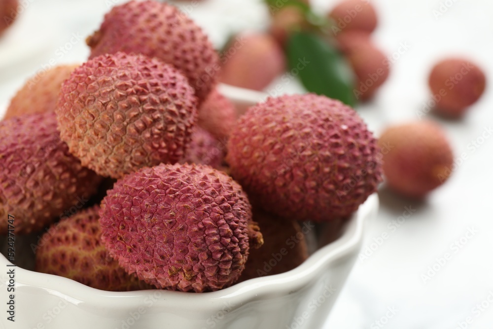 Fresh ripe lychee fruits in ceramic bowl on table, closeup Fresh ripe lychee fruits in ceramic bowl on table, closeup