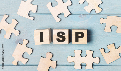 Blank puzzles and wooden cubes with the text ISP Internet Service Provider lie on a light blue background.