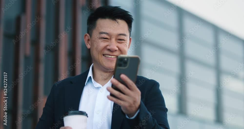 Man entrepreneur, browsing mobile phone in the background of the business center Man entrepreneur, browsing mobile phone in the background of the business center