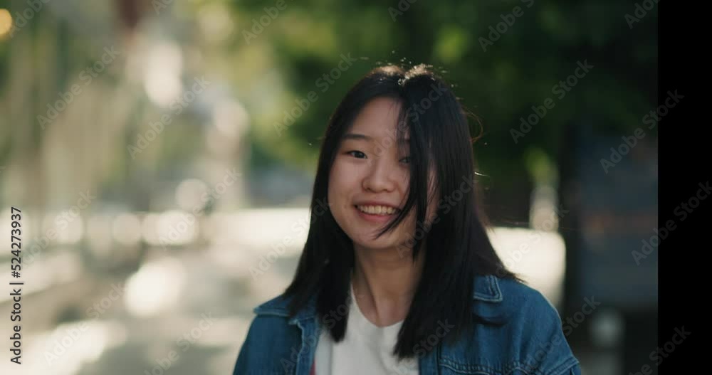 Asian girl walking, turning to the camera and smiling Asian girl walking, turning to the camera and smiling