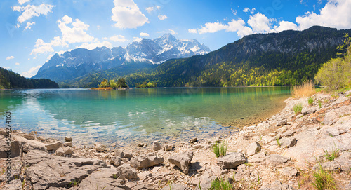 rocky bathing beach at lake shore Eibsee, view to Zugspitze mountain, upper bavarian summer landscape photo