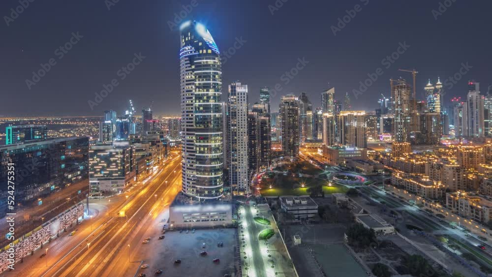 Dubai's business bay towers panorama aerial night timelapse. Rooftop view of some skyscrapers and new towers under construction with parking and traffic on the street Dubai's business bay towers panorama aerial night timelapse. Rooftop view of some skyscrapers and new towers under construction with parking and traffic on the street