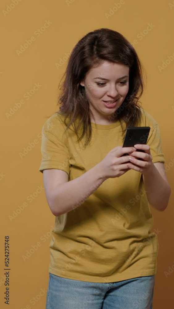 Portrait of woman holding smartphone looking at touchscreen texting friend recieving extraordinary good news wanting to jump for joy. Smiling person using mobile phone overwhelmed with happiness. Portrait of woman holding smartphone looking at touchscreen texting friend recieving extraordinary good news wanting to jump for joy. Smiling person using mobile phone overwhelmed with happiness.