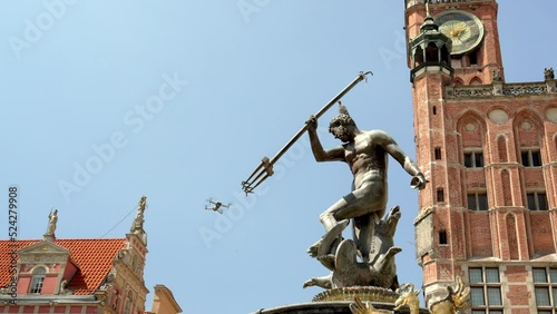 Fountain of Neptune near the building of the Town Hall of the Main City in the Long Market of Gdansk, a drone in the sky shoots a historical monument, a masterpiece of mannerism and rococo in Poland